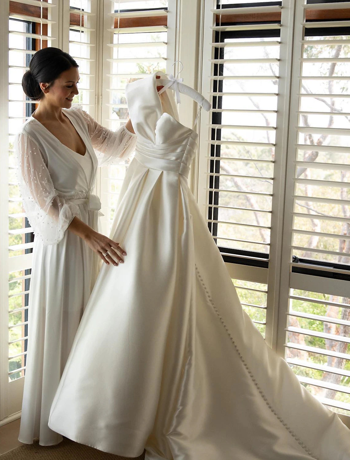 Close-up of the ruched detail on the bodice of the satin wedding dress.