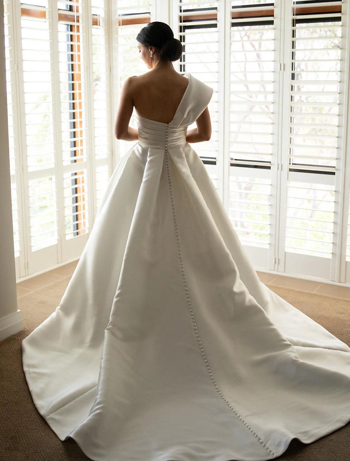 Back view of the A-line satin wedding dress, highlighting the elegant drape and train.