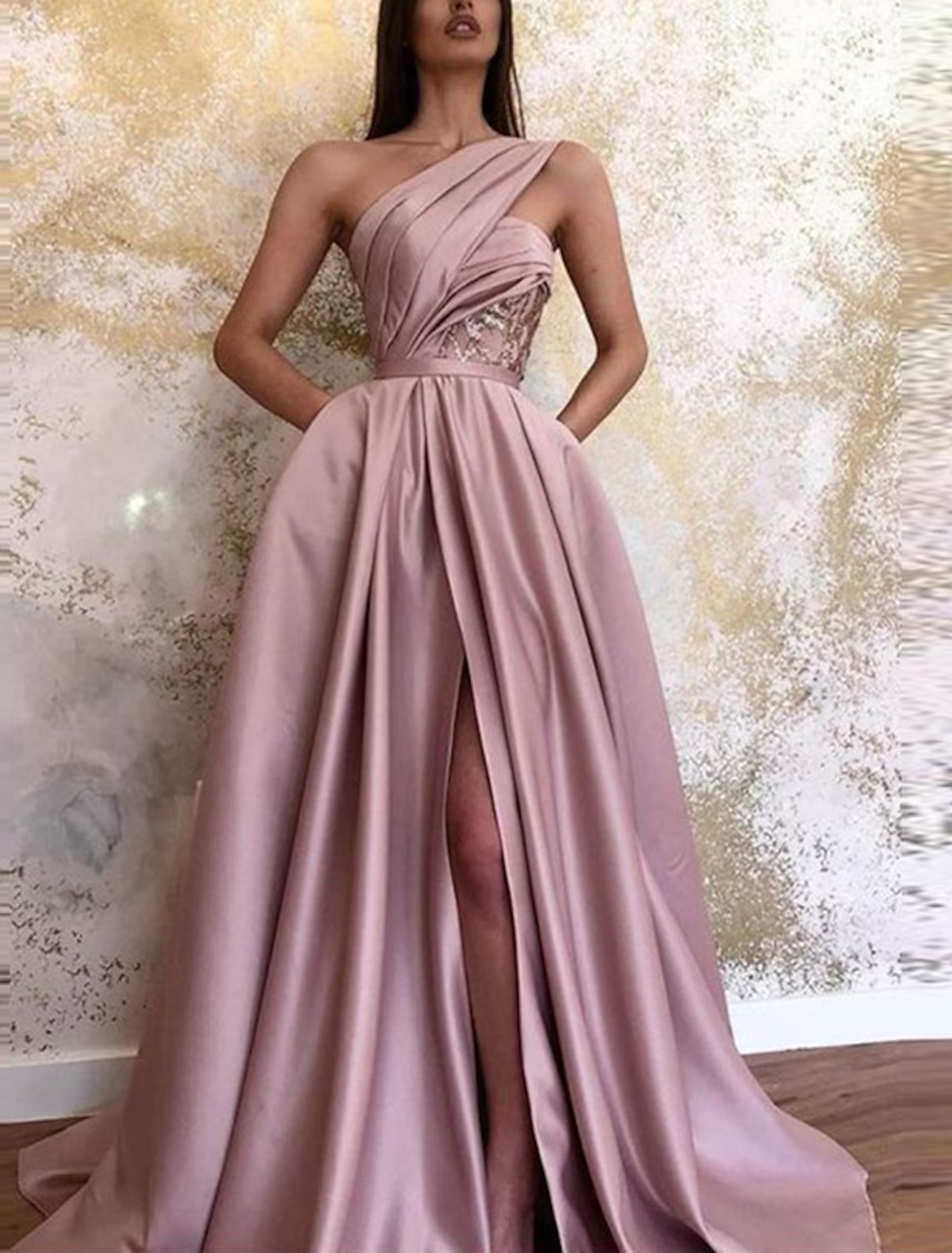Back view of an A-line one-shoulder satin evening gown with a flowing floor-length skirt.