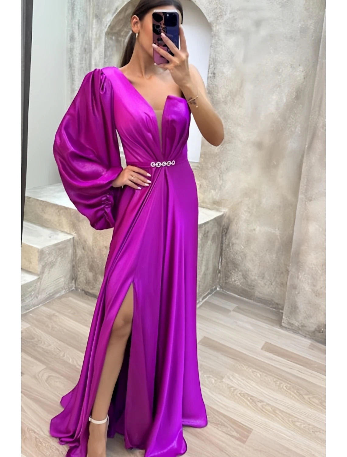 Side view of the one-shoulder satin gown with sweep train.