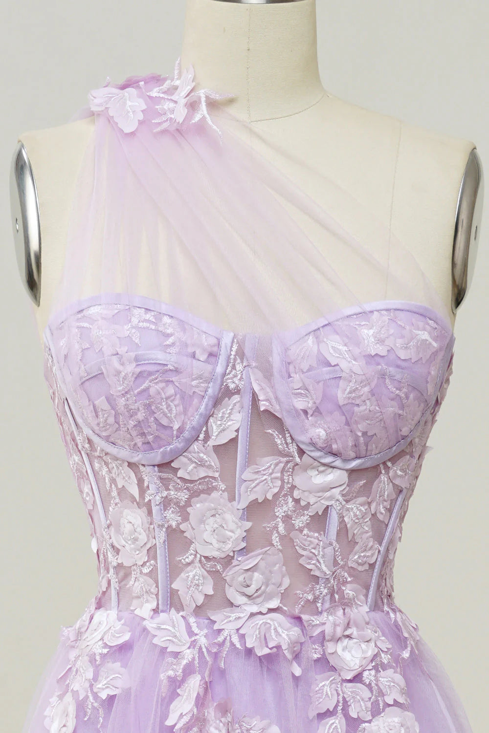 Close-up of appliques on purple one-shoulder prom dress.