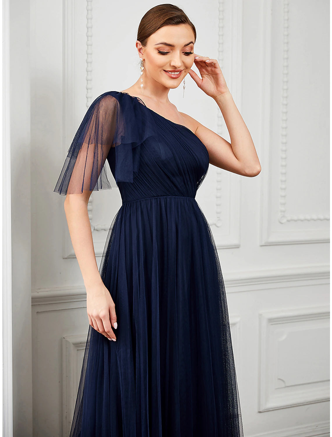 Close-up of the one-shoulder neckline and flower detail on the dress.