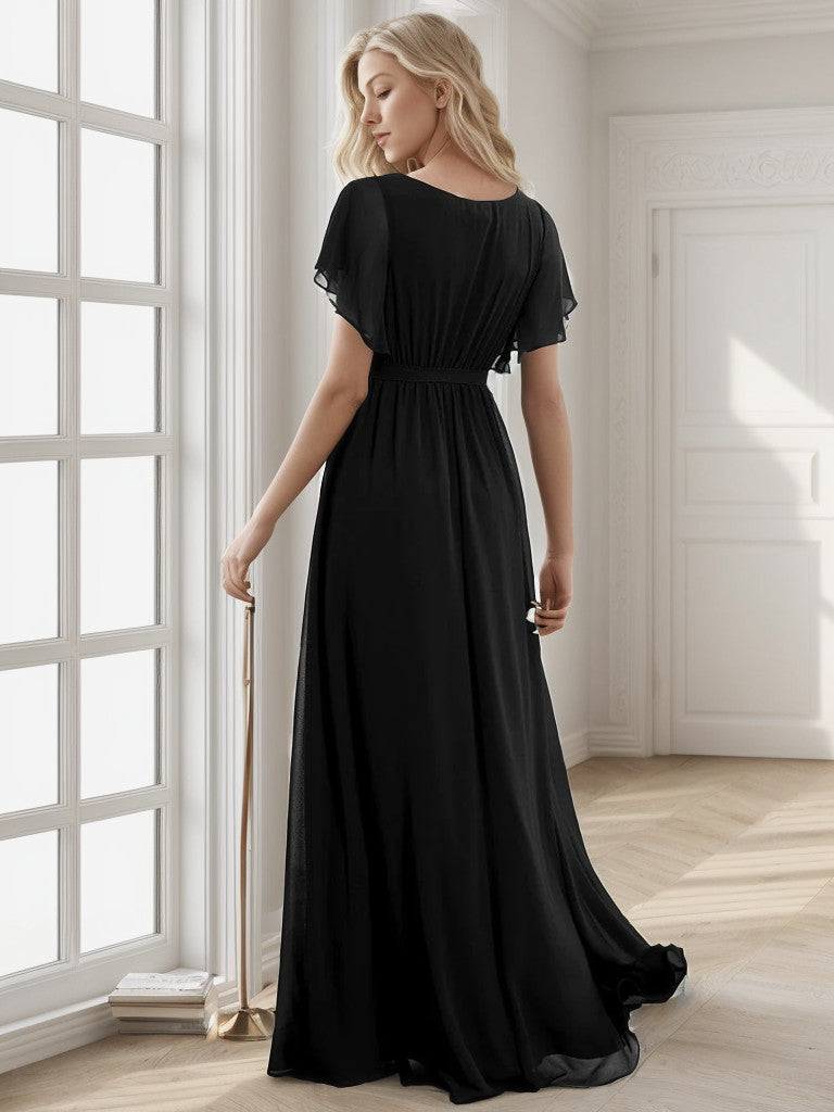 Woman wearing a black A-Line pleated chiffon dress.