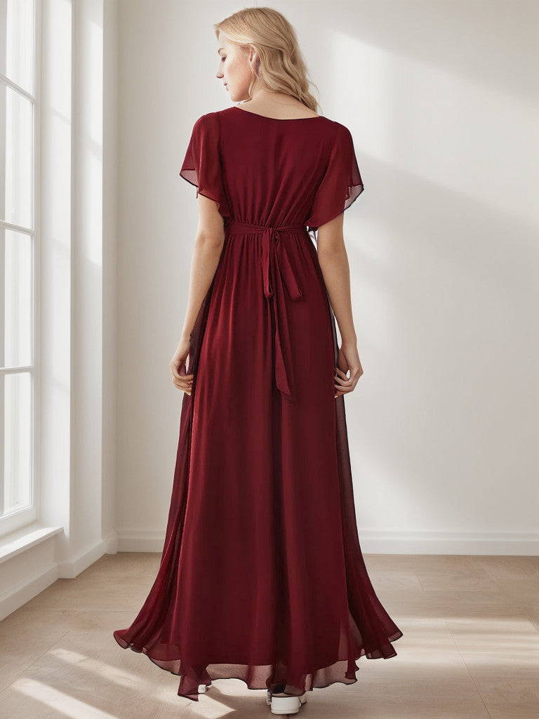 Woman posing in a burgundy A-Line pleated chiffon dress.