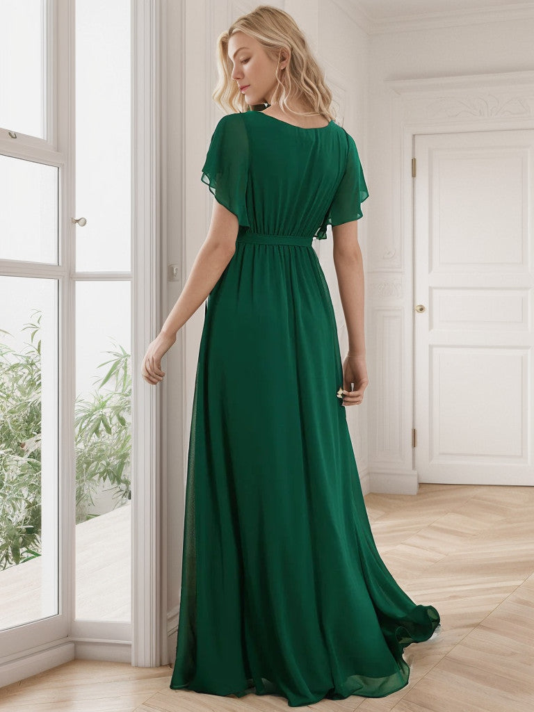Woman wearing a dark green A-Line pleated chiffon dress.