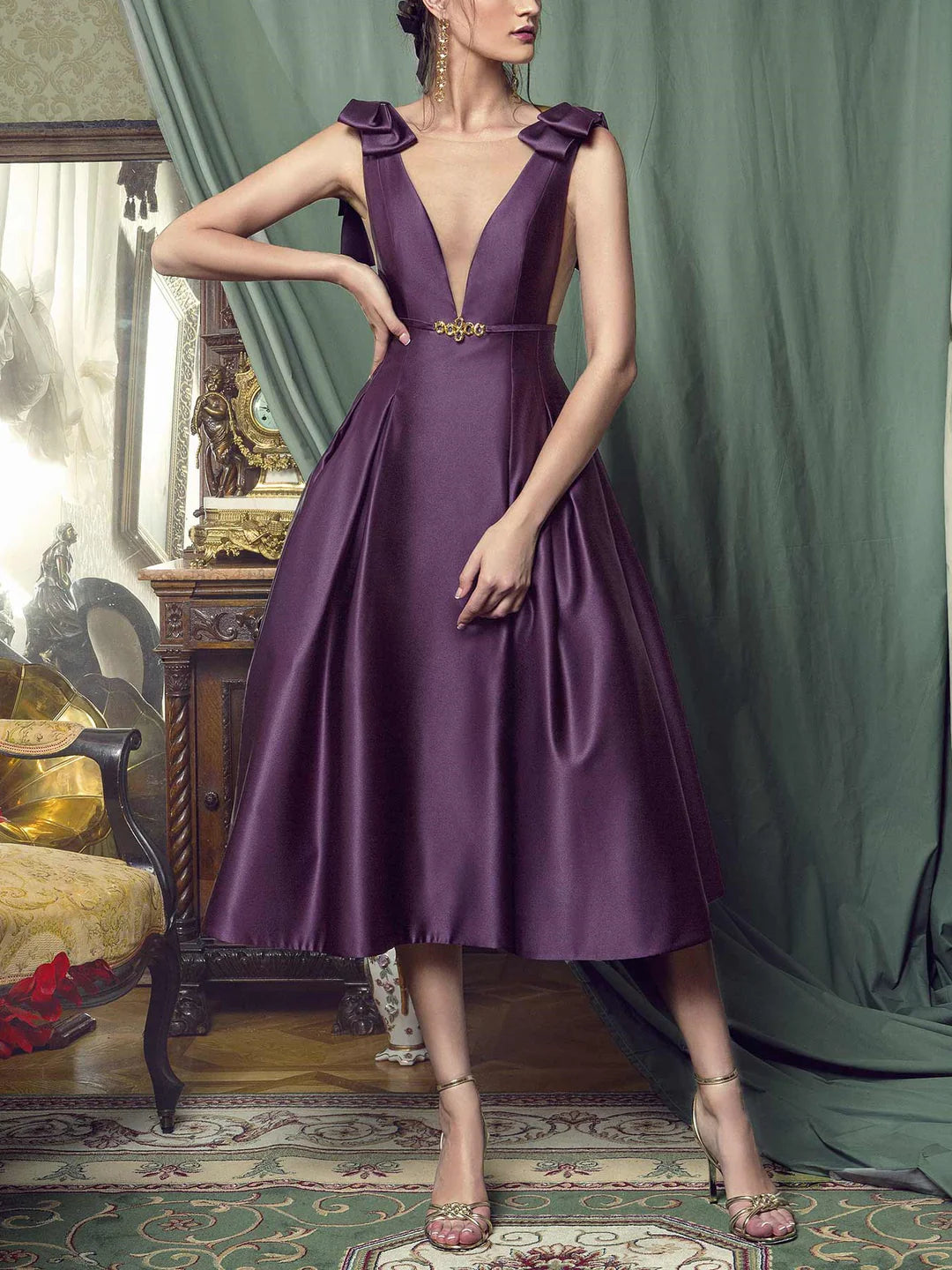 Model wearing an elegant A-line plunging neckline sleeveless knee-length cocktail dress.