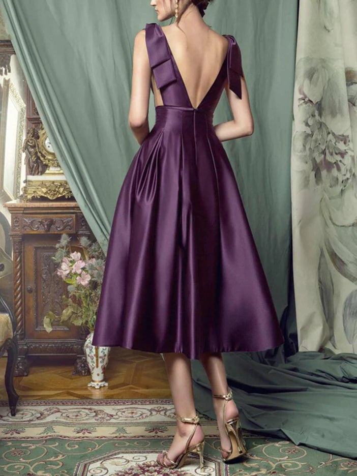 Model showcasing the back of an A-line knee-length formal dress.