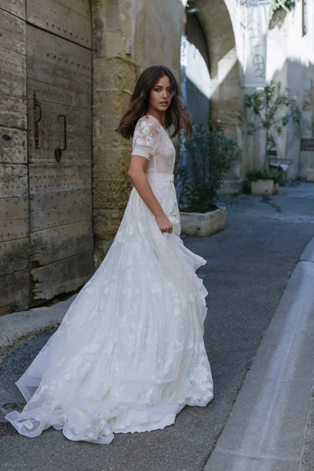 Side view of the long tulle bridal gown, showcasing its flowing A-line skirt.