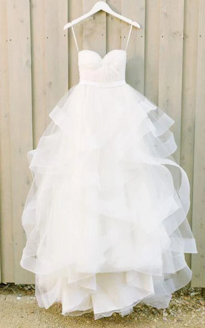 Woman wearing an elegant A-Line Princess wedding dress with short sleeves and a chapel train.