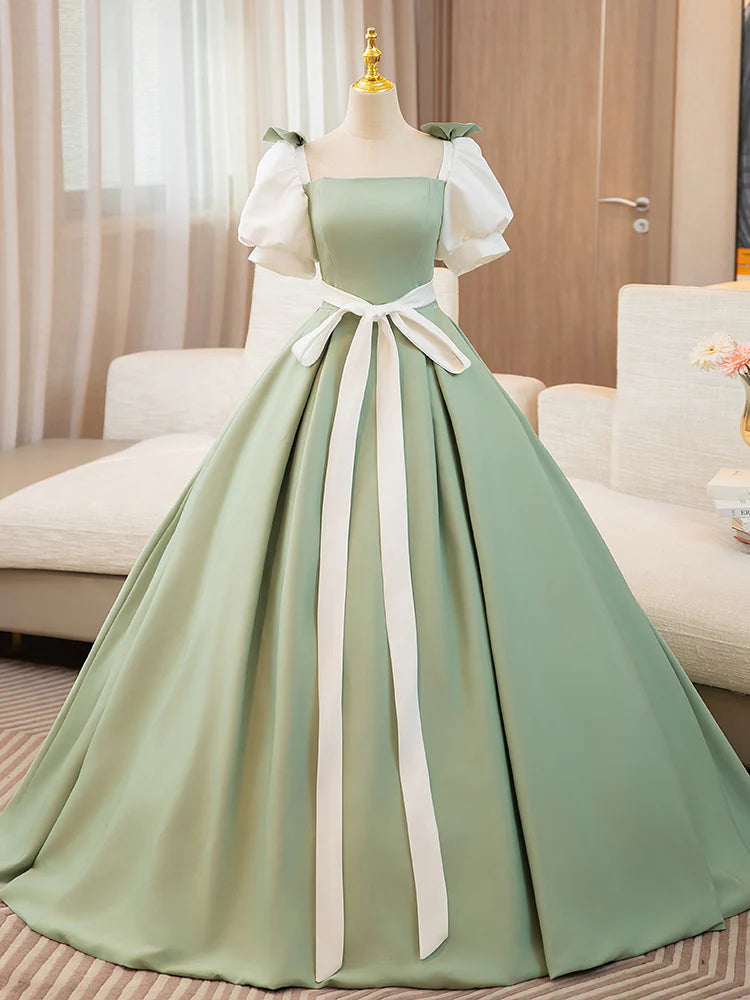 Woman posing gracefully in a long A-line satin prom gown.