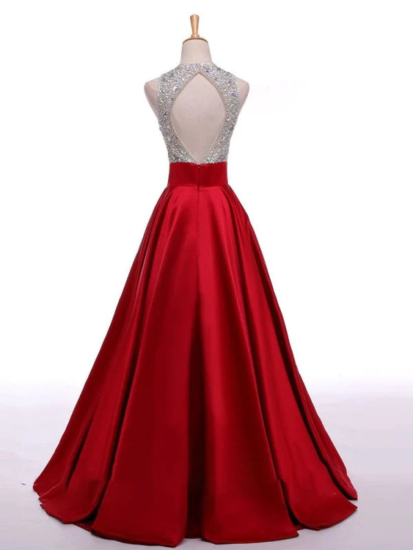 Full view of a woman in a long A-line beaded prom dress.