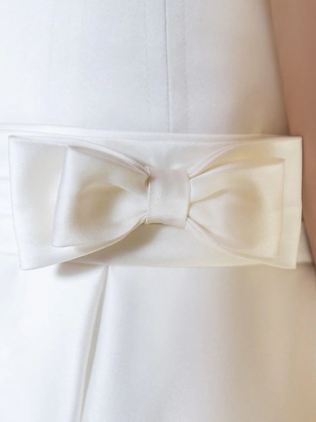 Girl posing in a white A-line first communion dress.