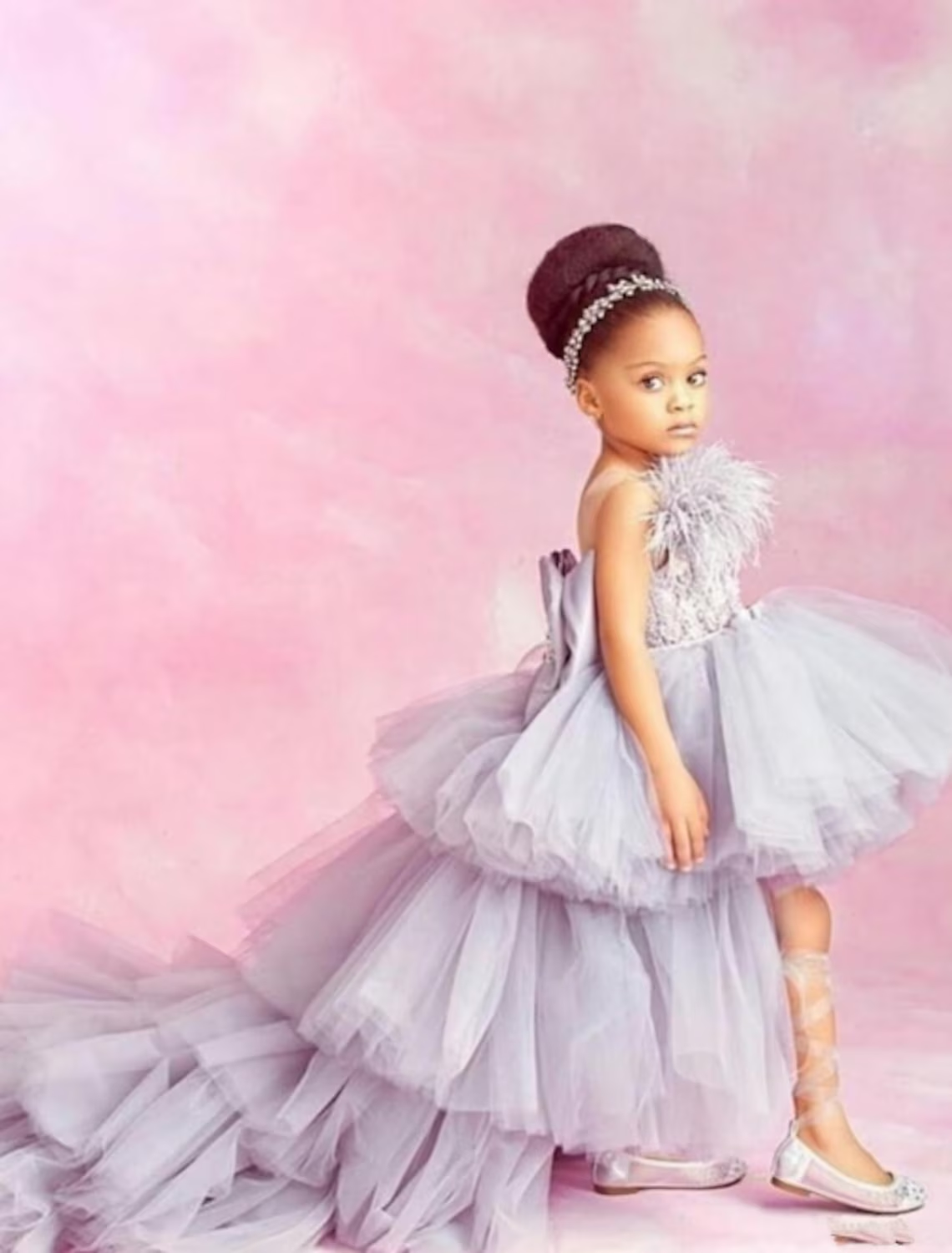 Close-up of the tiered skirt and feather embellishments on the flower girl dress.