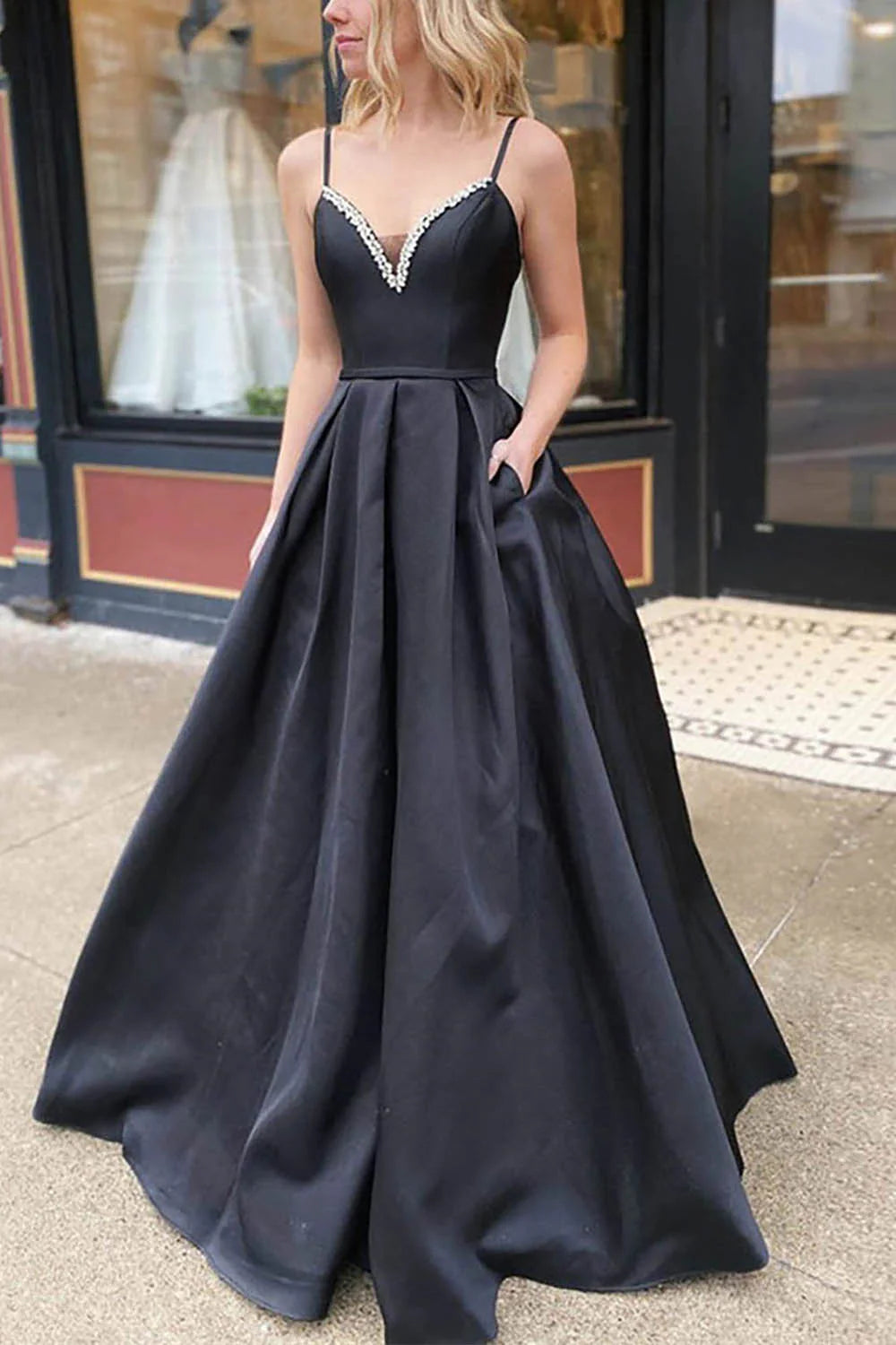 Elegant A-line satin prom dress with spaghetti straps and V-neck, worn by a model.