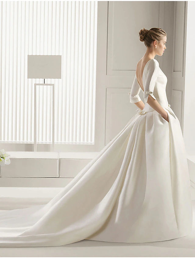Back view of A-line satin wedding dress showing court train and pleats.
