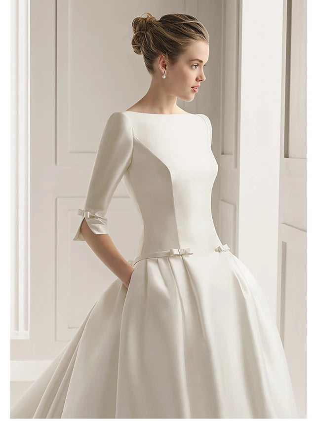 Side view of A-line satin wedding dress with bow detail.