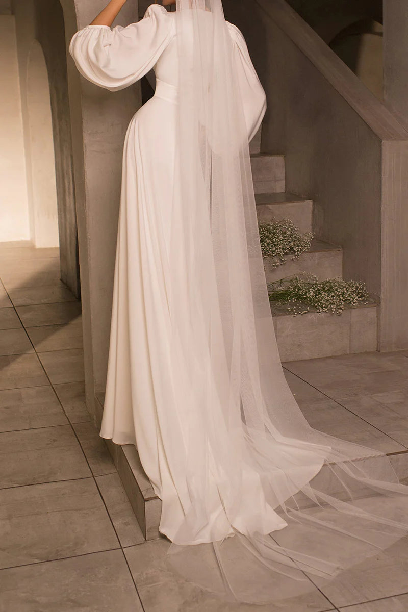 Back view of an A-line satin wedding dress, showcasing the sweep train and graceful long sleeves.