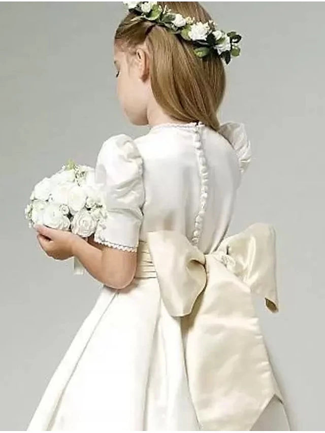 Back view of a white A-line satin flower girl dress, highlighting the sash.