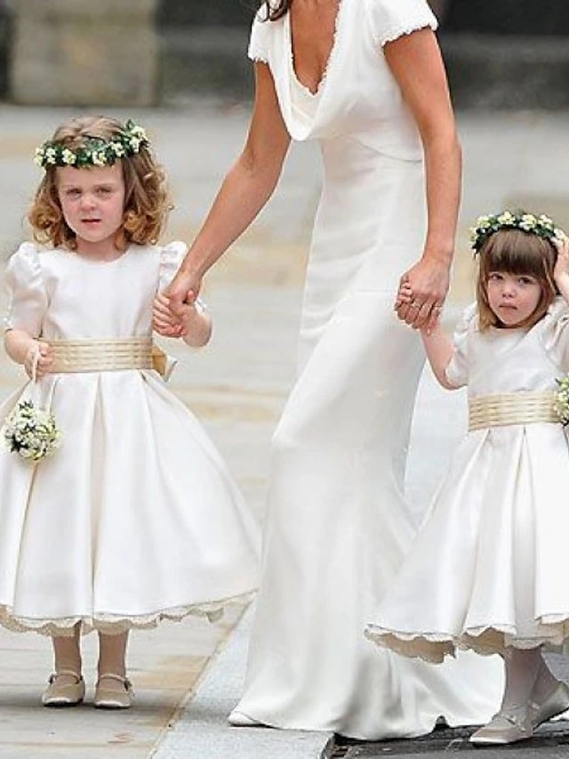 Girl walking in a white A-line satin flower girl dress, showing its flow.