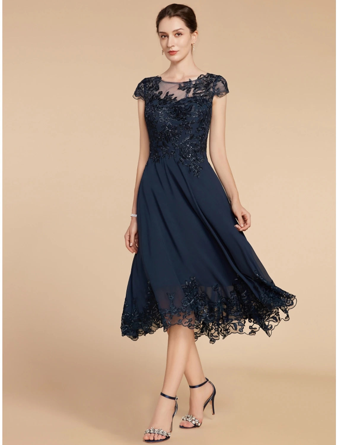 Model wearing the A-line dress, highlighting the tea length and cap sleeves.