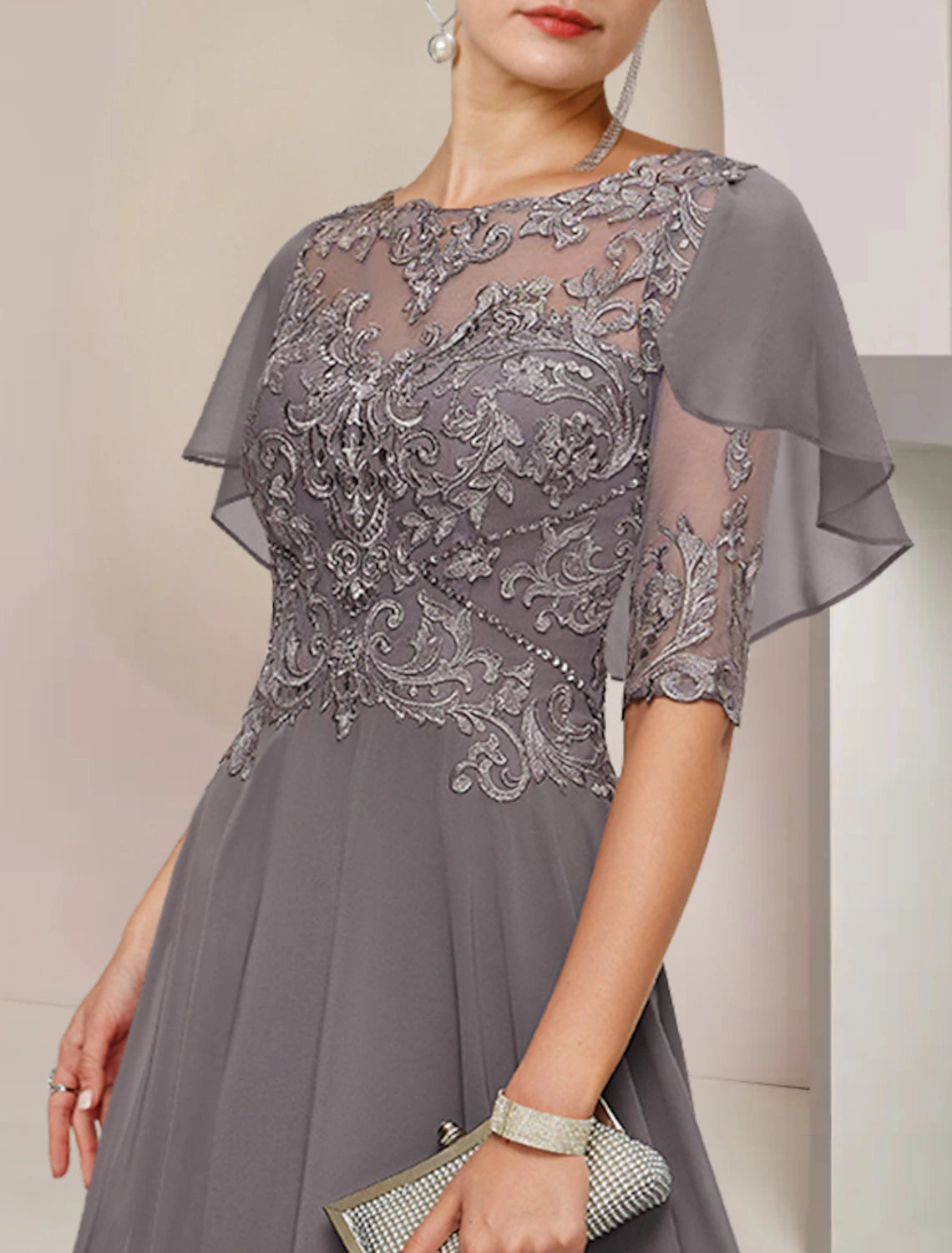 Close-up of intricate lace and beading on the dress's half sleeve.