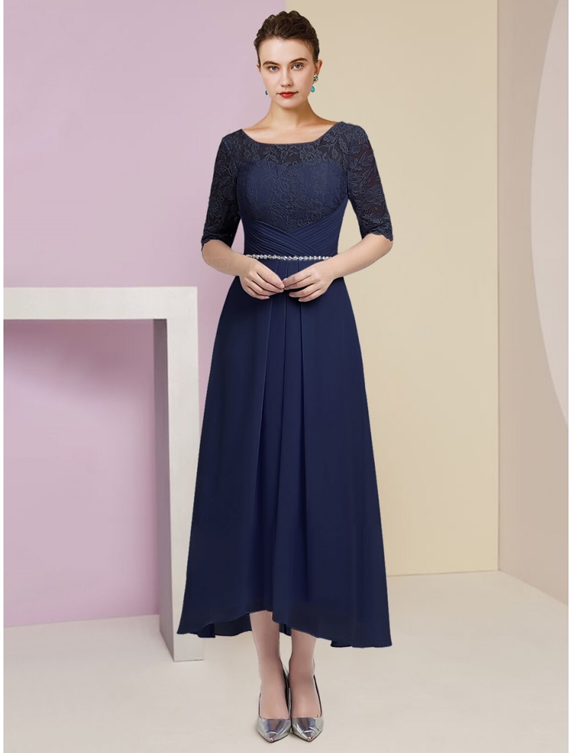 Close-up of the scoop neck, ruched bodice, and crystal embellishments on the dress.