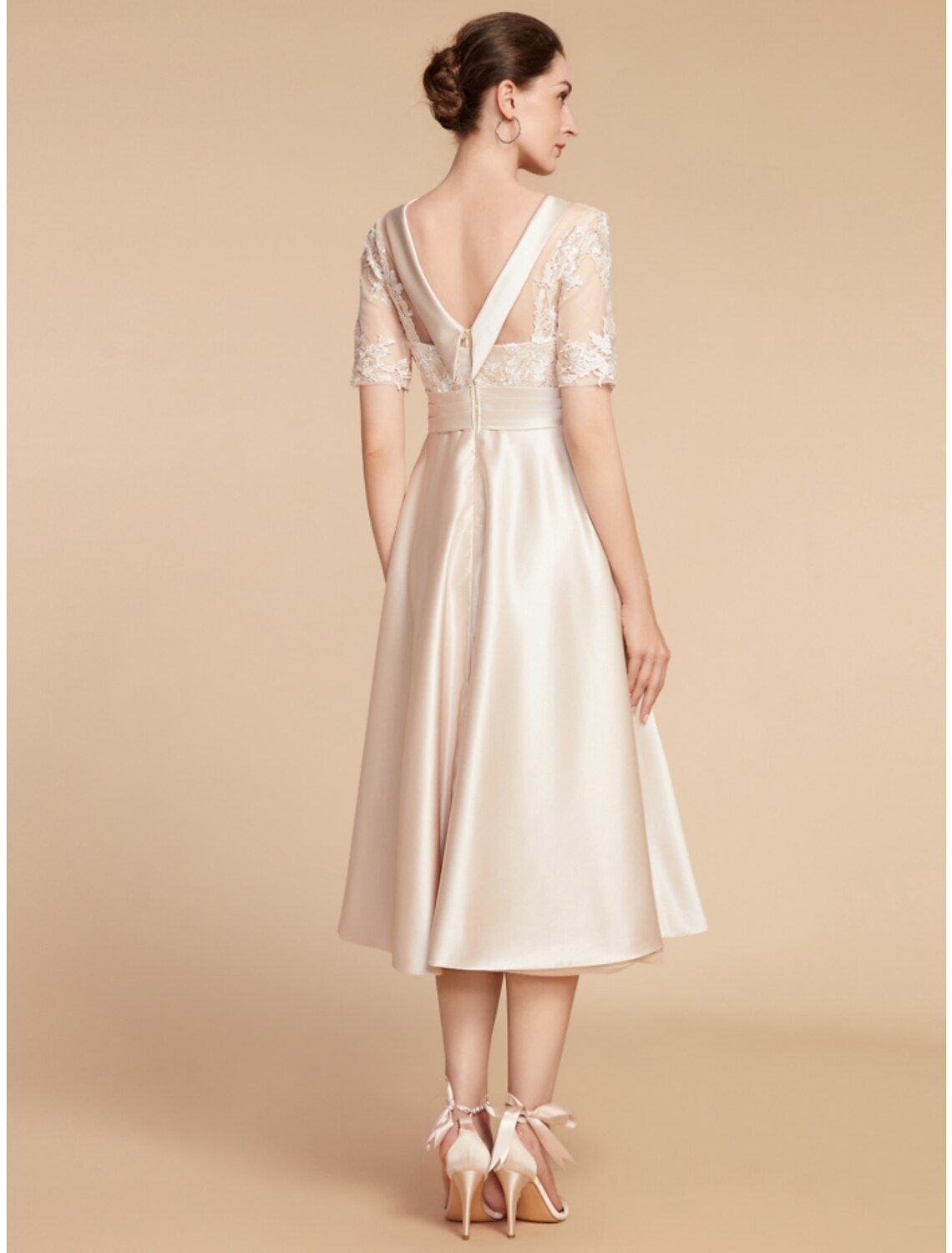 Woman posing in the elegant A-line knee-length dress, showing its flow.
