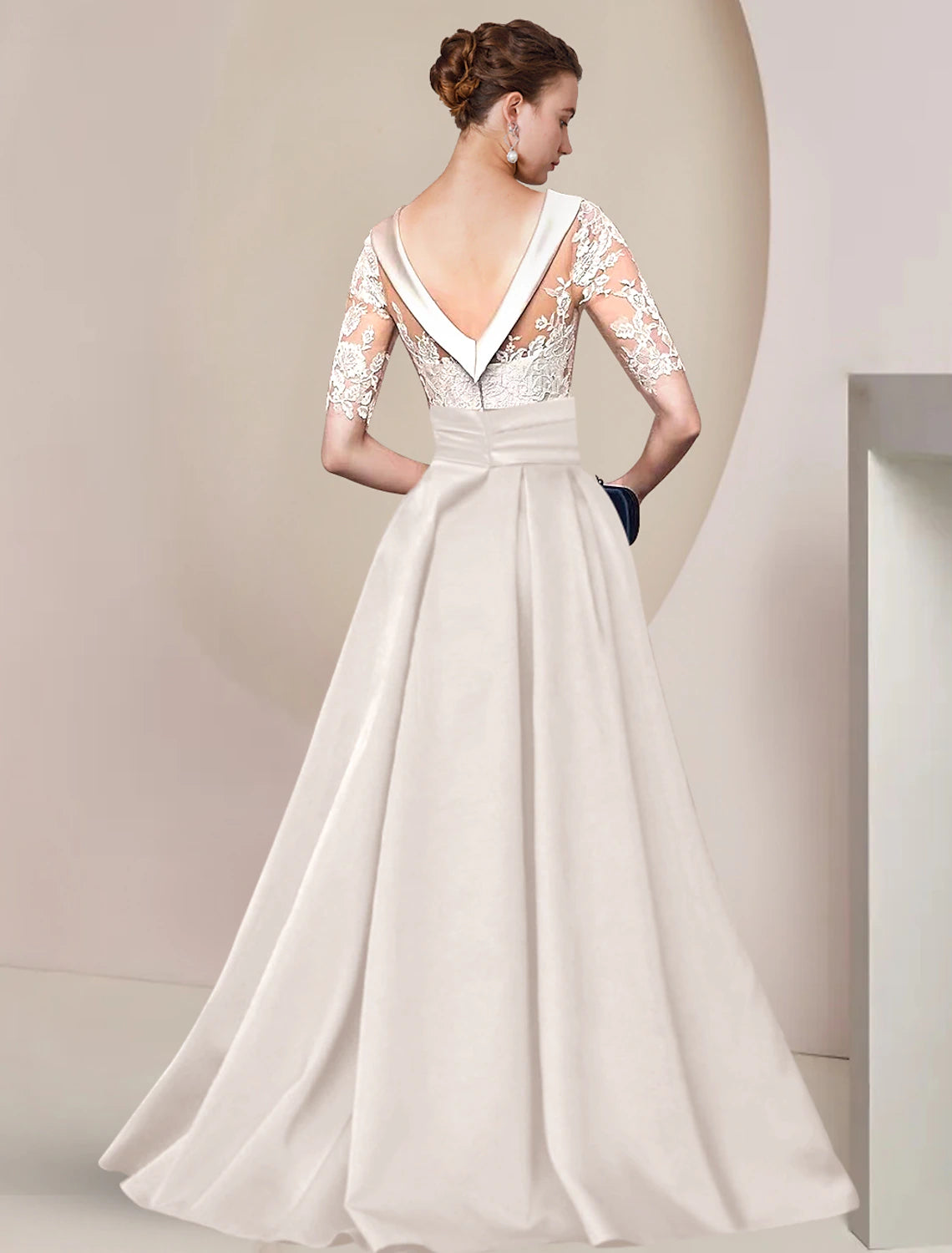Back view of A-line Mother of the Bride gown featuring a sweep train and ruched appliques.