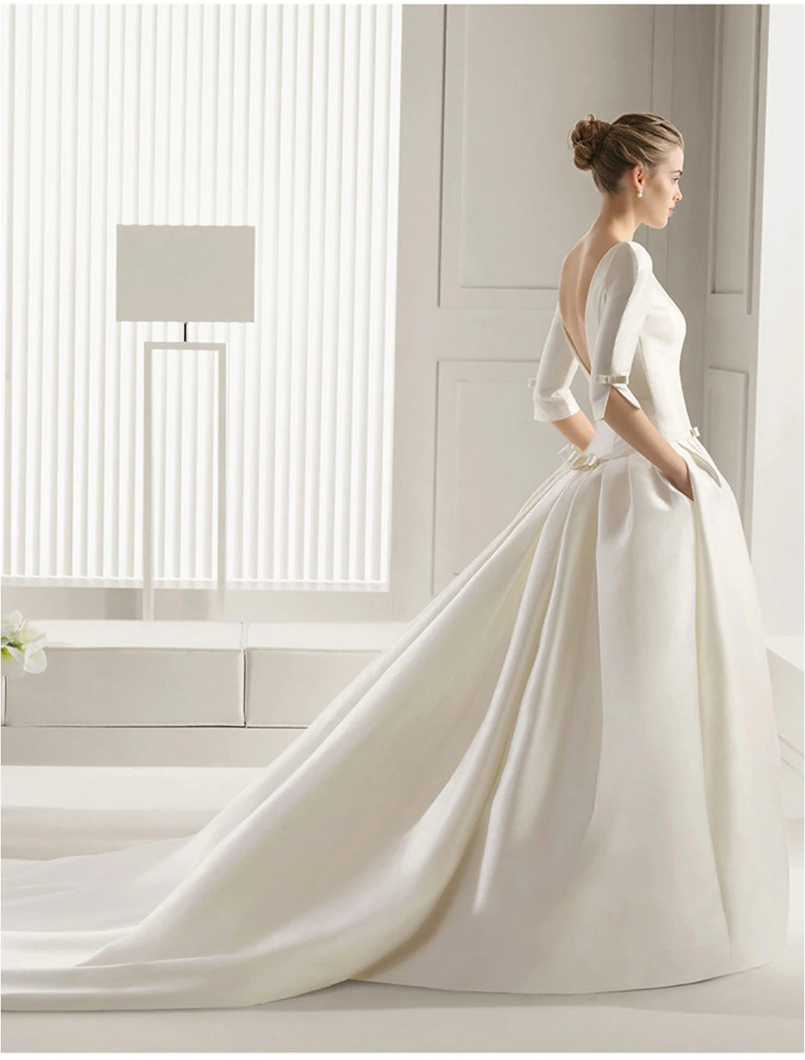 Back view of the A-line satin wedding gown showing court train and pleats.