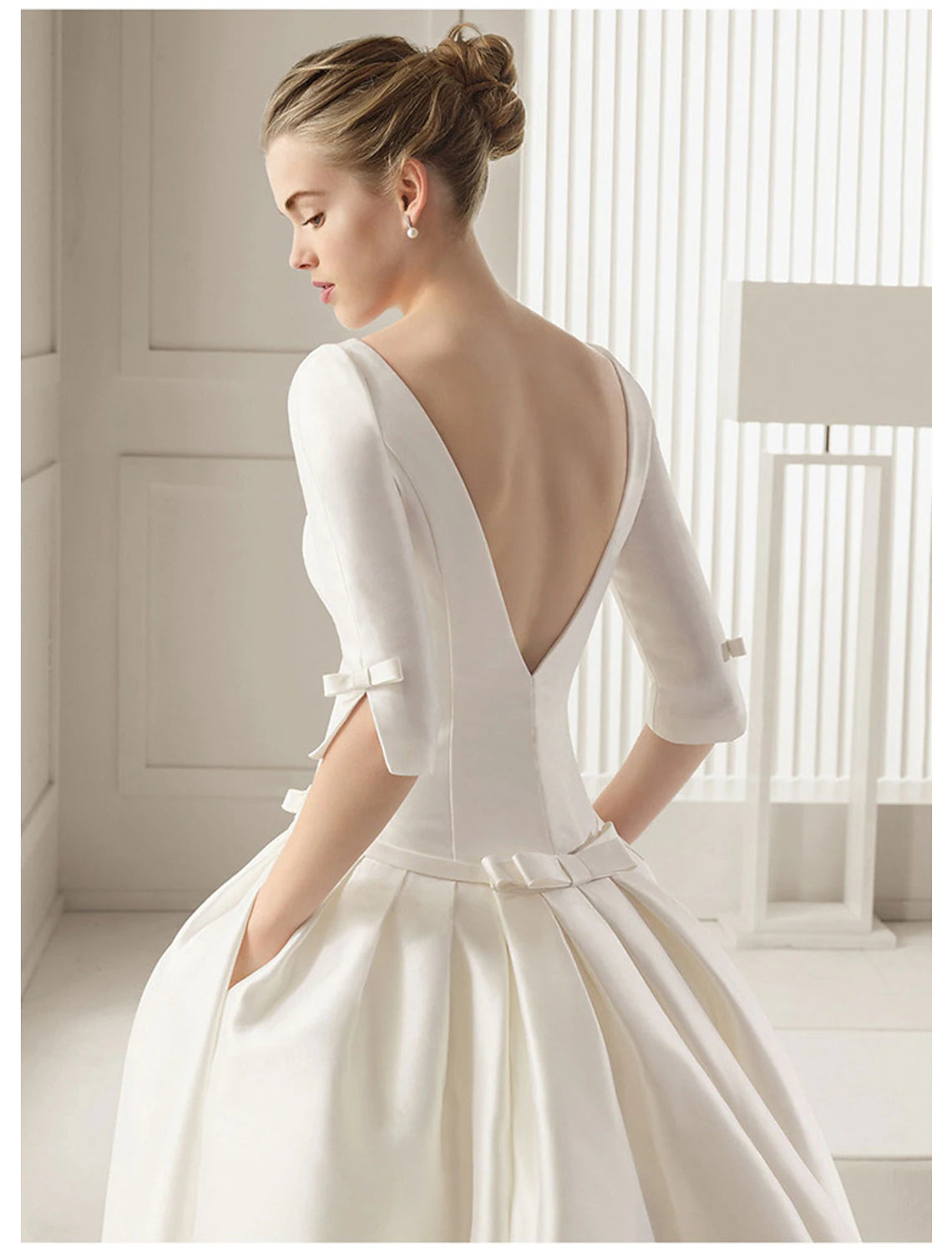 Close-up of the scoop neckline and half sleeves on the satin bridal gown.