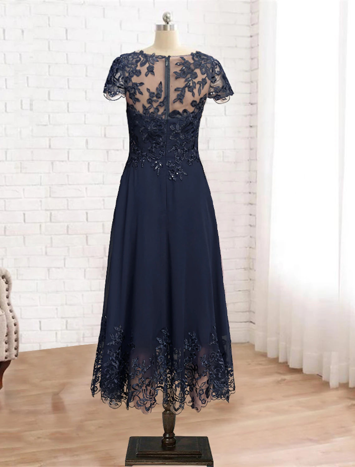 Tea-length formal dress featuring sequin appliques and elegant silhouette.