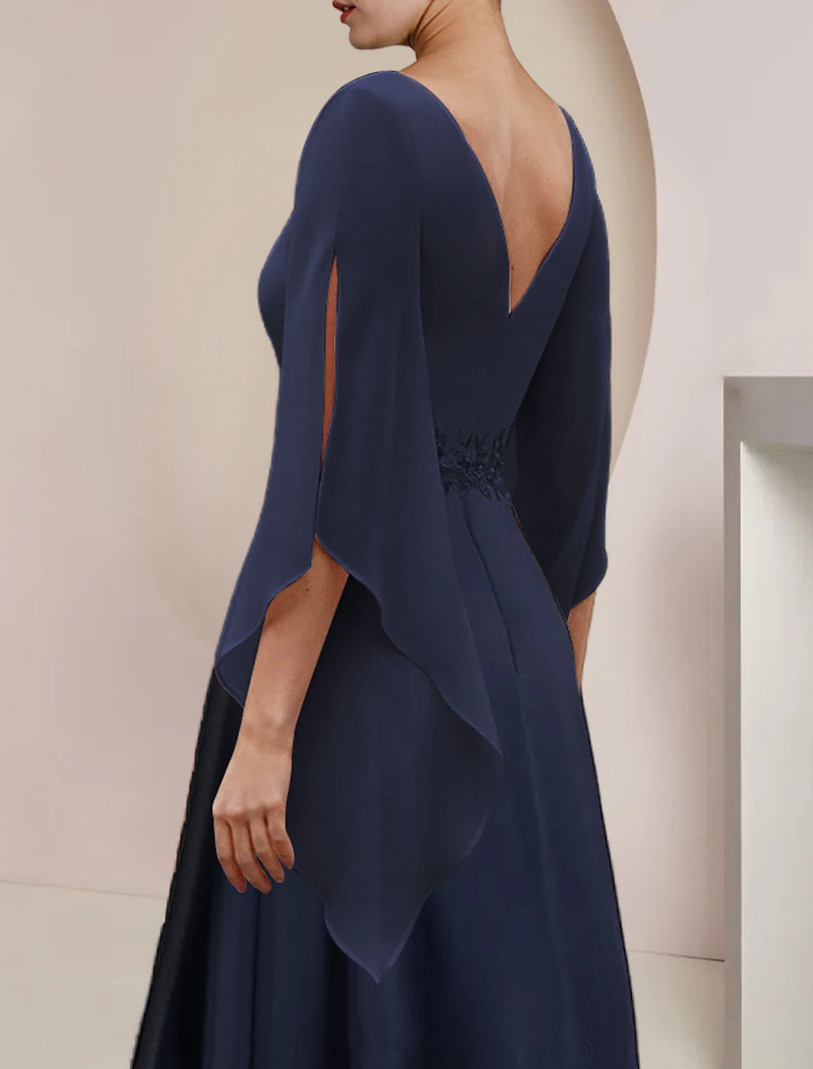 Close-up of delicate lace appliques on the 3/4 sleeve of the chiffon dress.