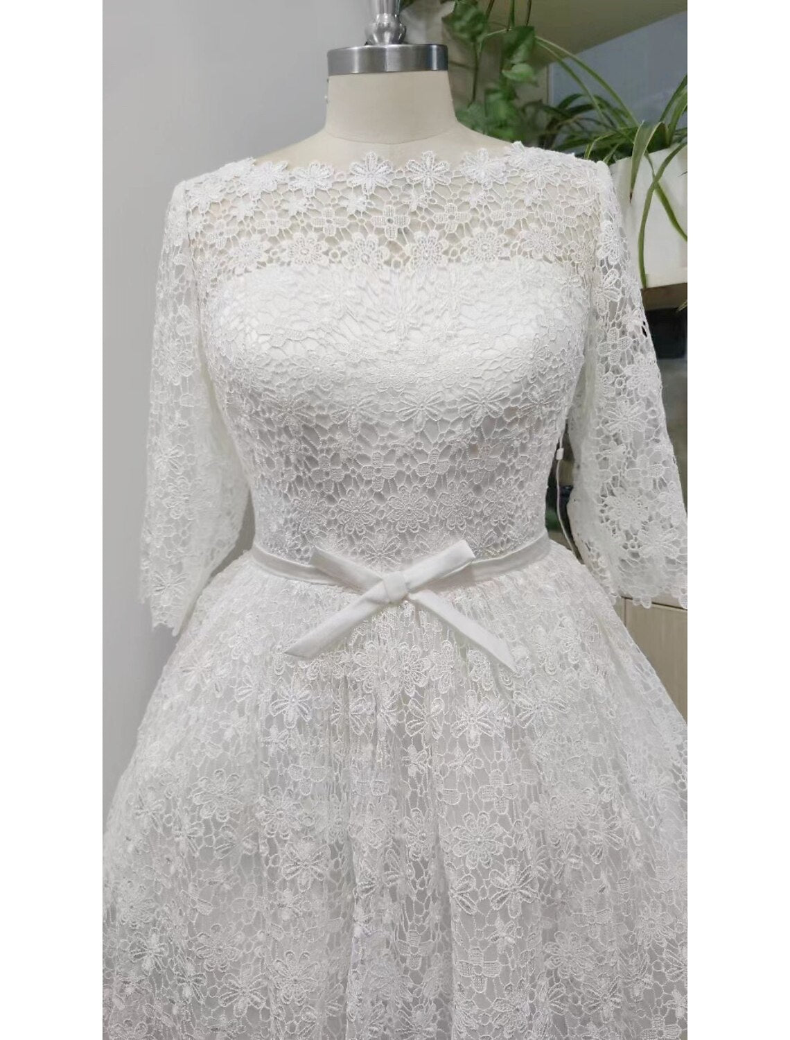 White A-line reception wedding dress with scoop neck, 3/4 sleeves, and lace details.