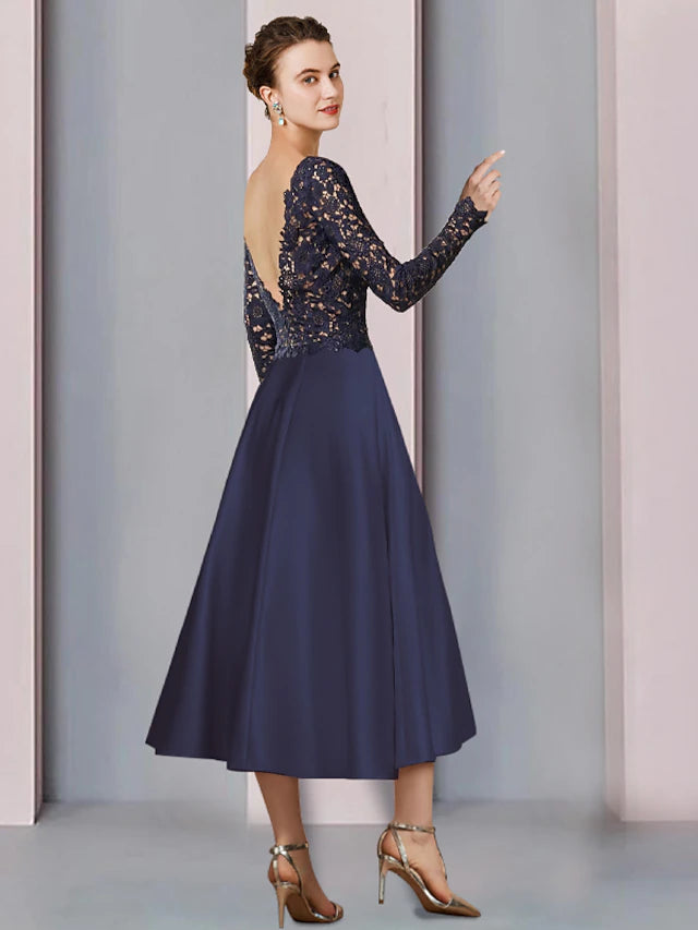 Close-up of the satin lace fabric, pleats, beading, and appliques on the tea length dress.
