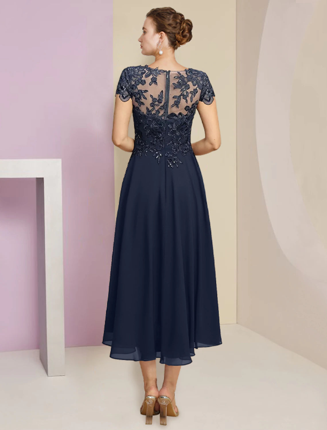 Back view of formal tea length dress with sequin appliques and pleats.
