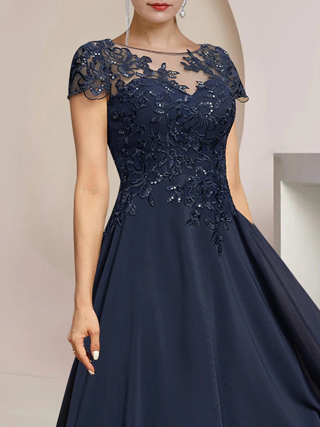 Close-up of the sequin appliques and lace detailing on the short sleeve of the elegant formal dress.