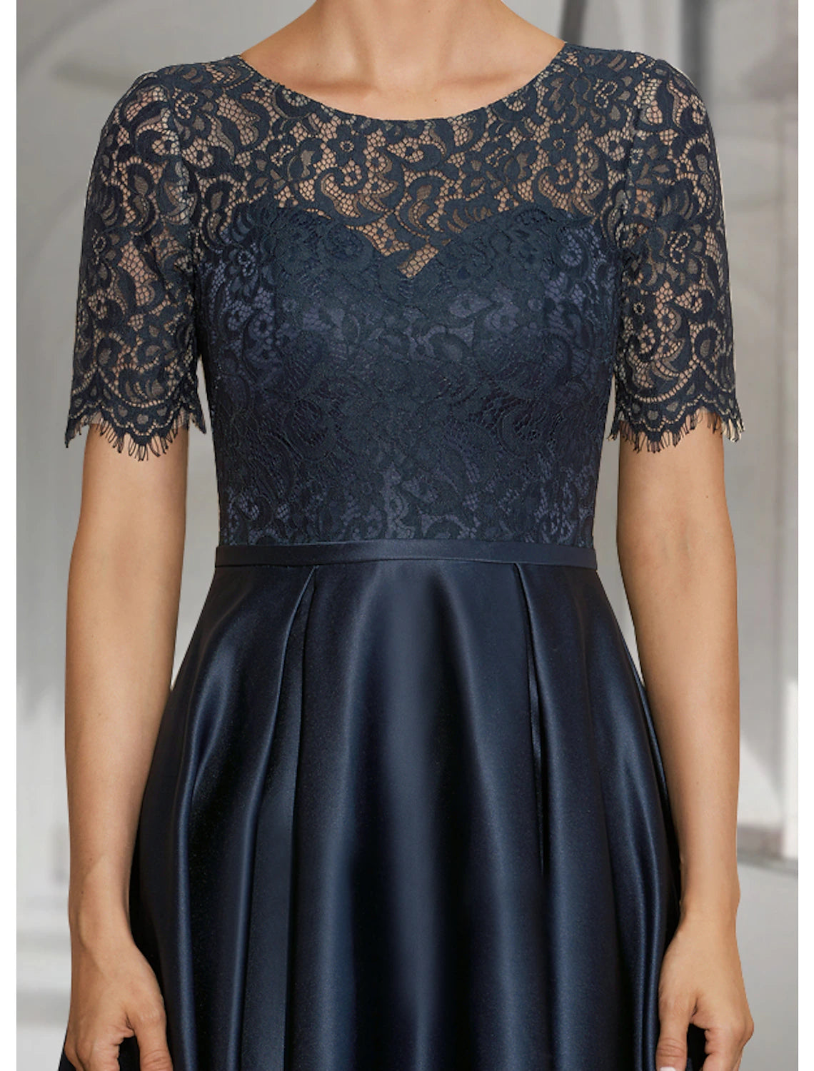 Back view of the elegant satin and lace A-line dress with a scoop neckline.