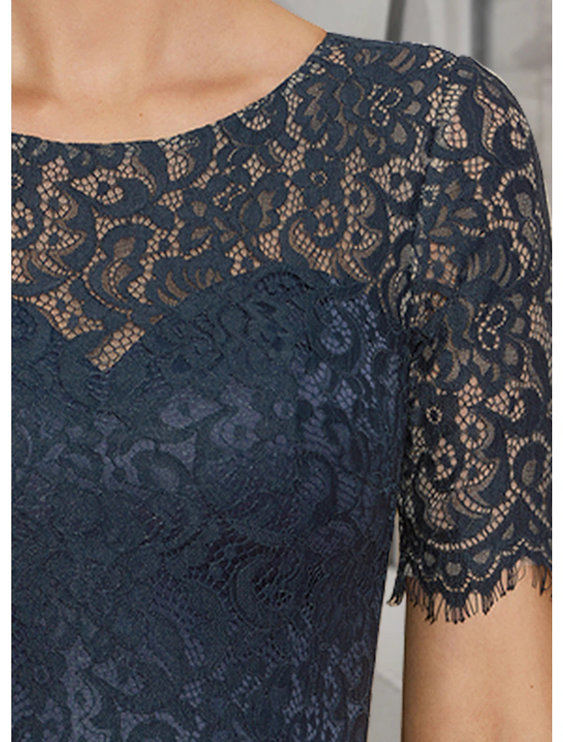 Close-up of the delicate lace and pleated details on the short sleeve of the A-line dress.