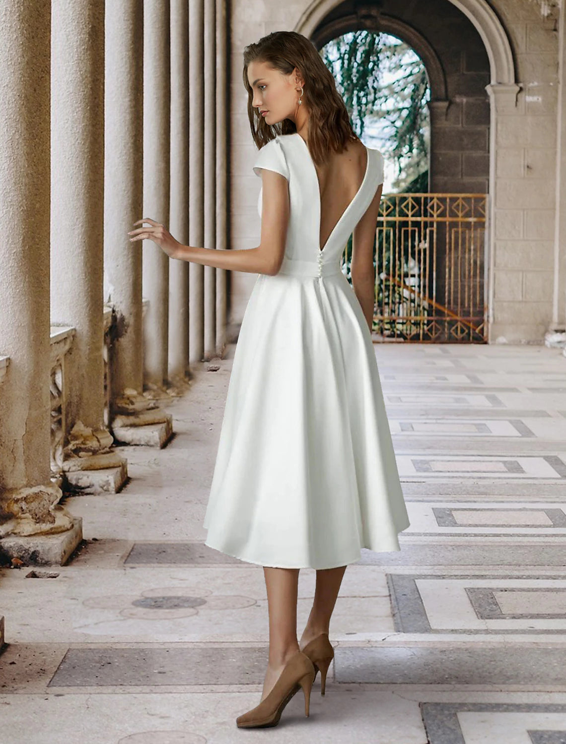 Back view of a white A-line wedding dress, highlighting the pleated satin fabric.