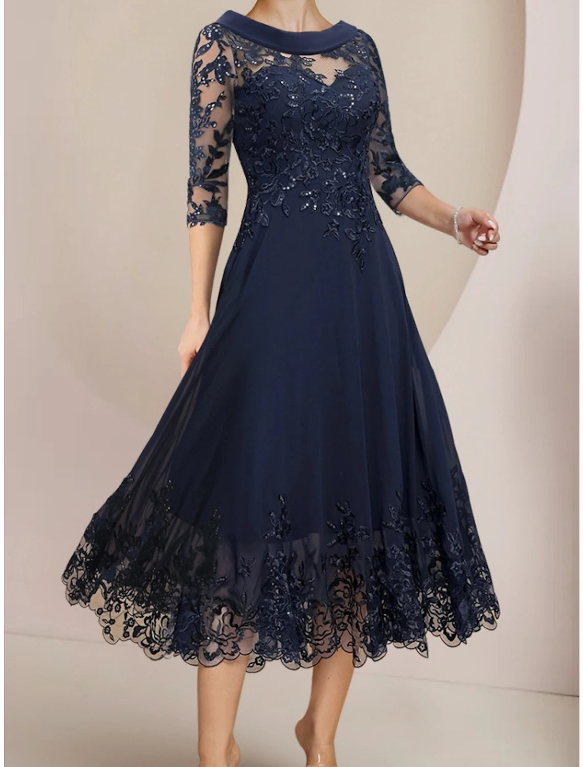 Woman wearing a sophisticated chiffon lace tea length dress with sequin ruching.