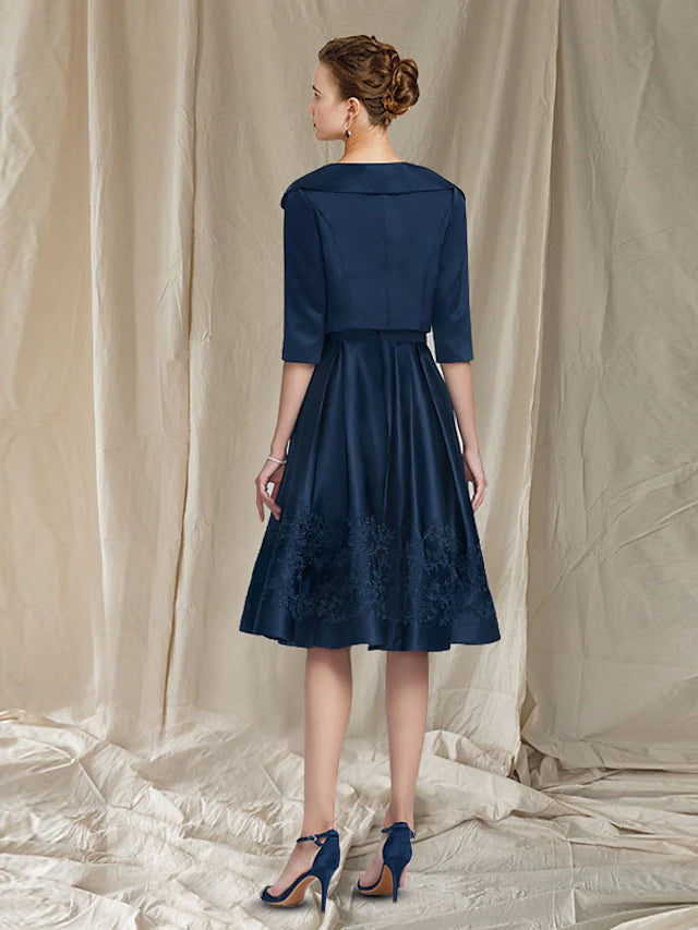 Side view of the two-piece satin and lace dress with appliques.