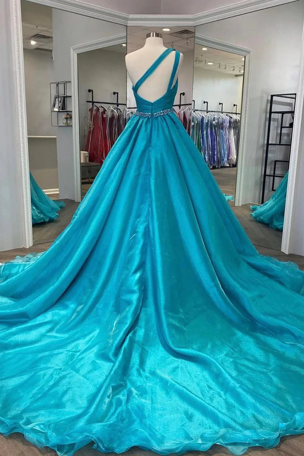 Elegant sky blue A-line prom dress with a beaded waist, side view.