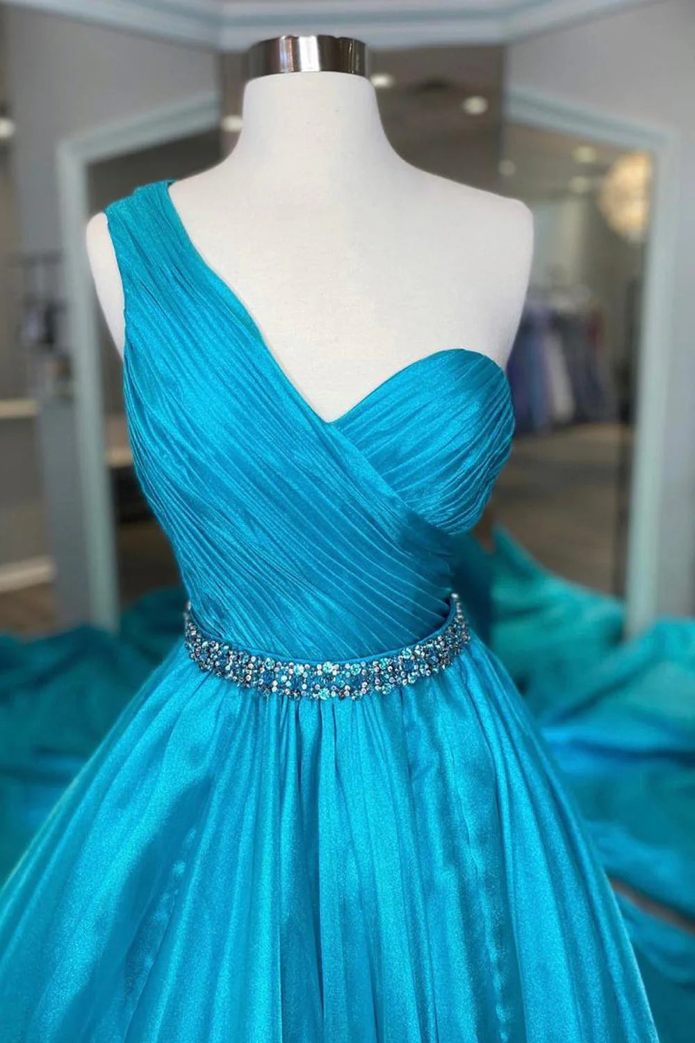 Elegant sky blue A-line prom dress with a beaded waist, back view.