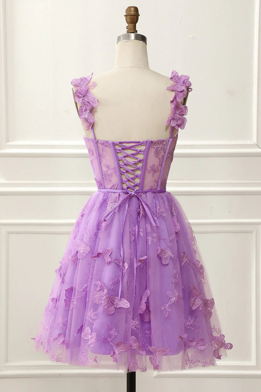 Back view of the short prom dress featuring spaghetti straps and a flowing skirt.