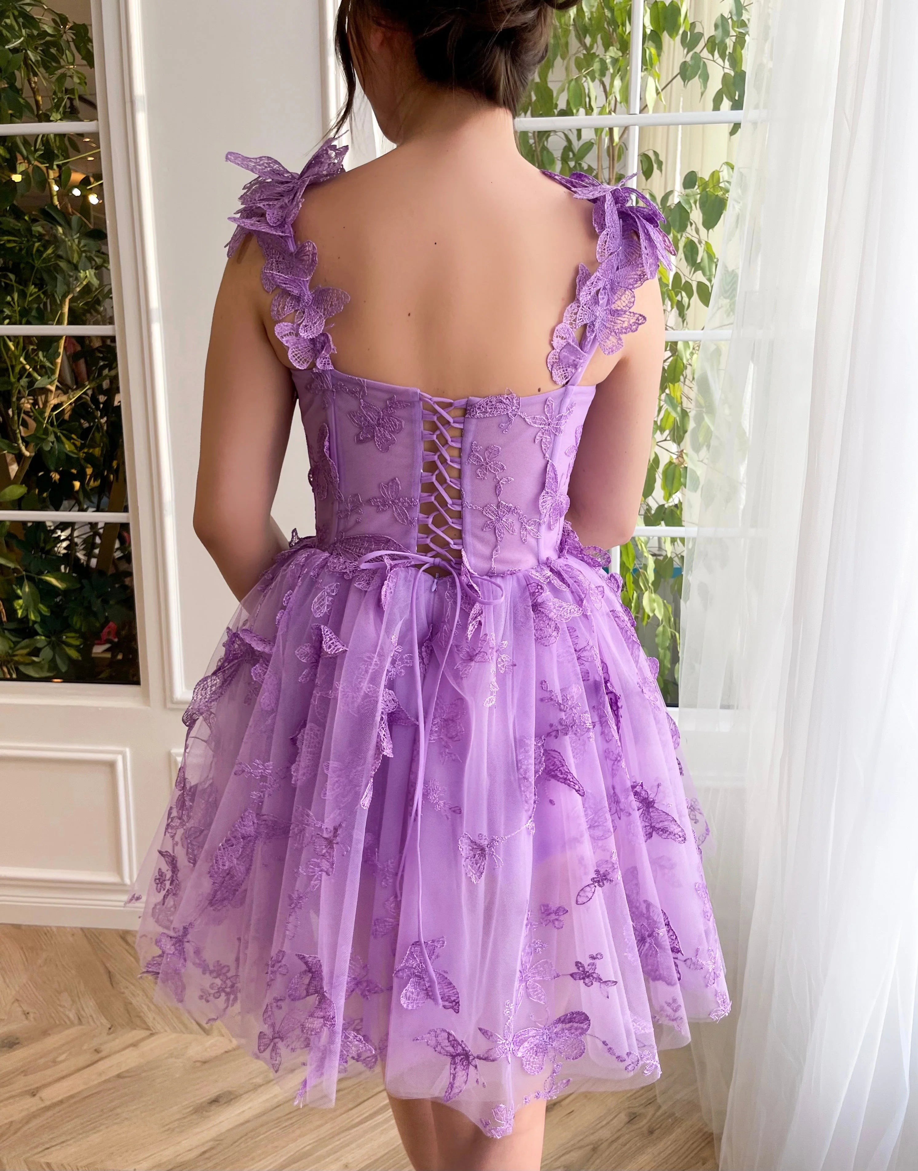 Full length view of the short evening gown with spaghetti straps and intricate butterfly details.