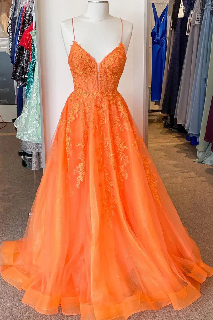 Orange A-Line prom dress with spaghetti straps, lace appliques, and corset bodice.