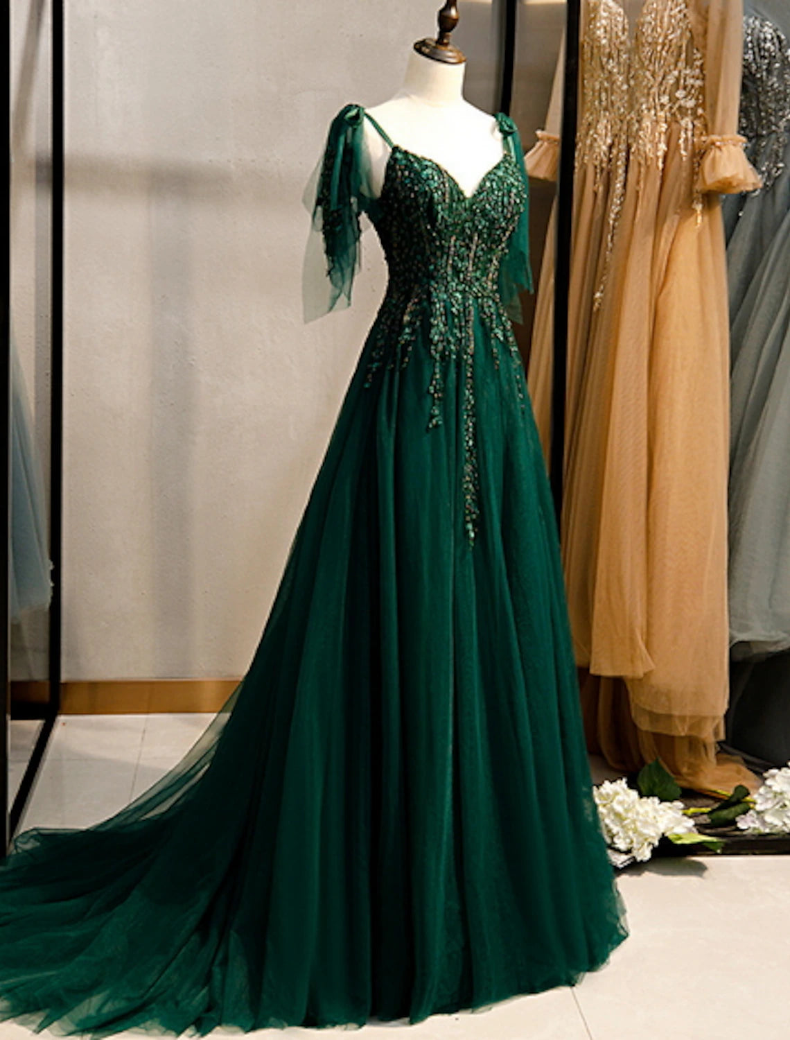 Side view of an A-line formal dress, highlighting the sweep train and intricate beading.