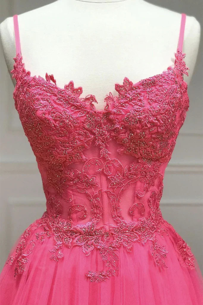 Back view of a woman in a long A-line prom dress featuring delicate spaghetti straps and lace.
