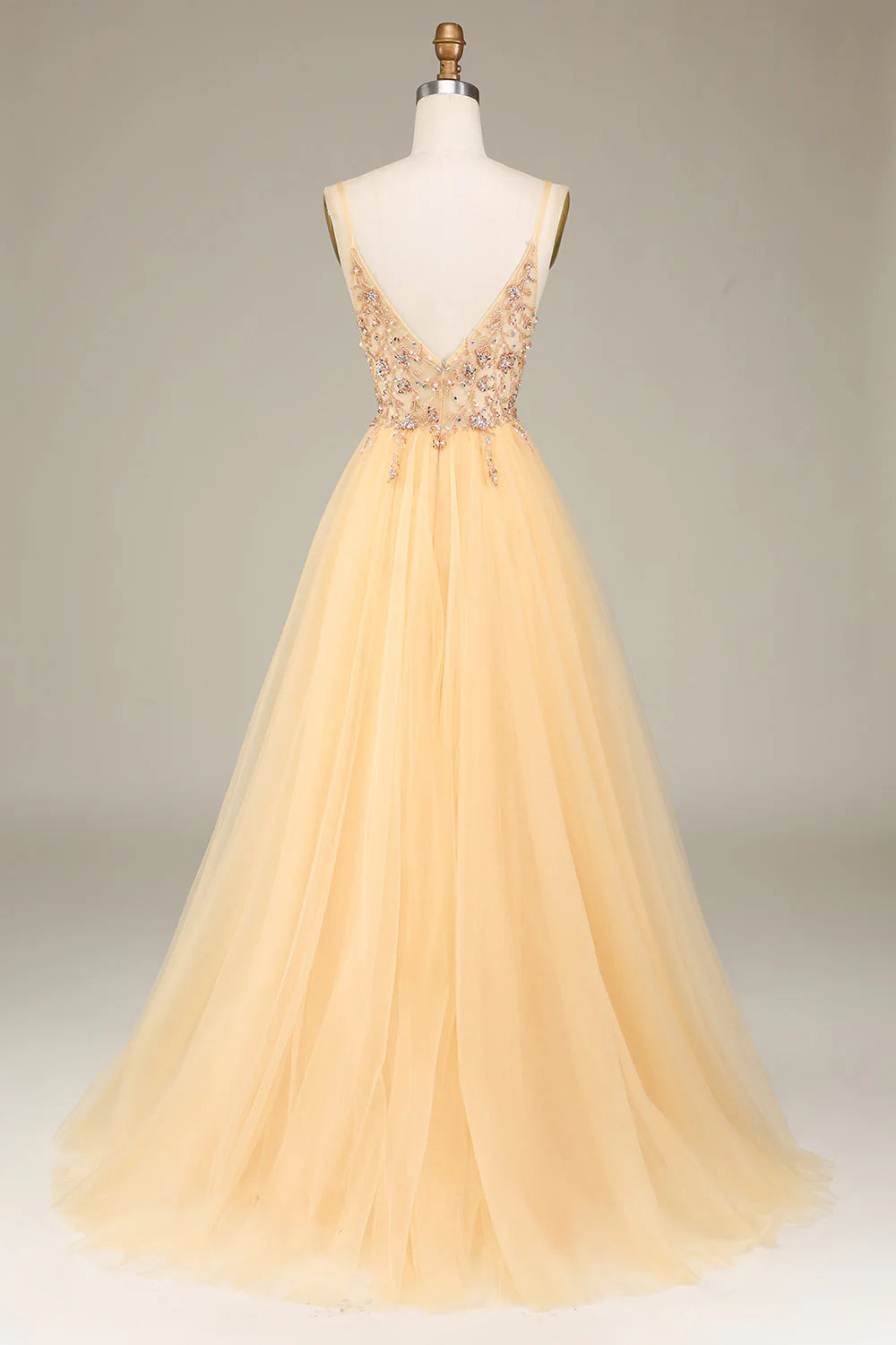 Back view of a golden A-line prom dress with delicate beading.