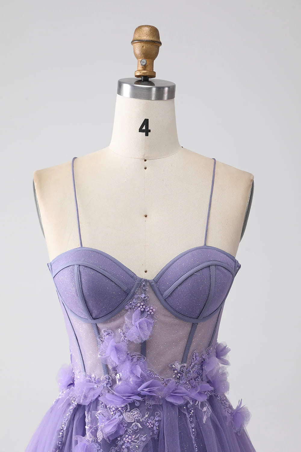 Close-up of the 3D floral embellishments on a purple prom dress.